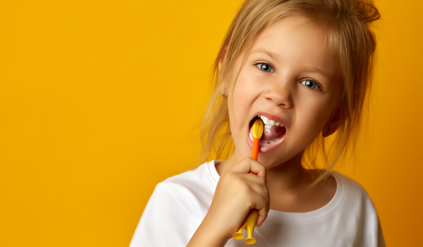 child brushes his teeth